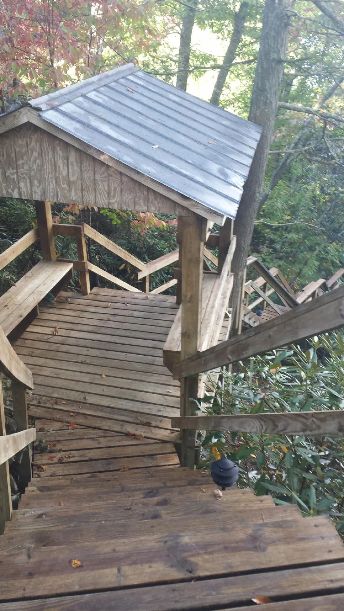 Metal roofed shelter over wooden steps on a wooded walkway — Skylight Repair & Installation work by our crew in Aliquippa