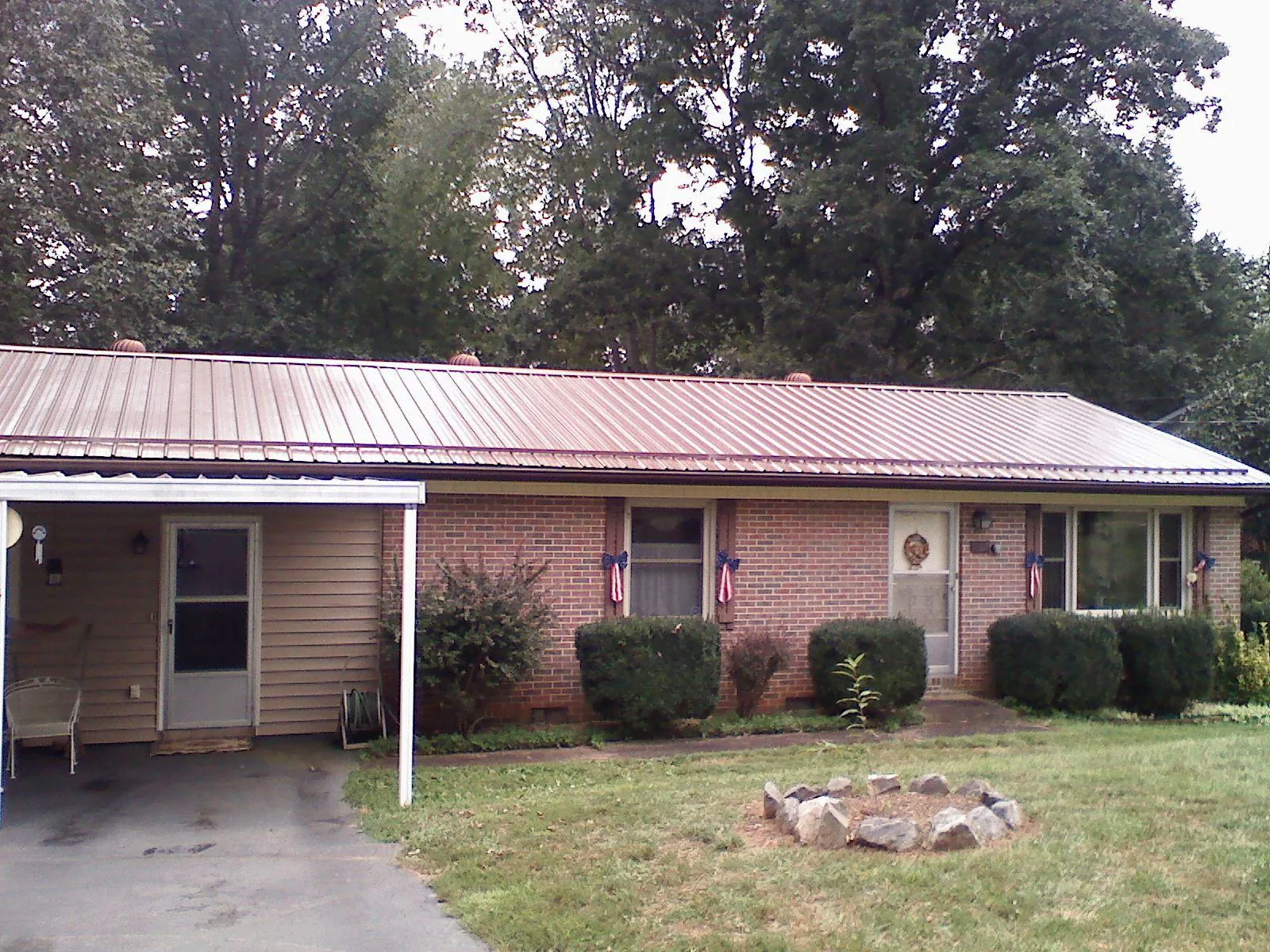 Bronze metal roof and carport on a brick ranch home — Roof Repair work by our crew in Aliquippa